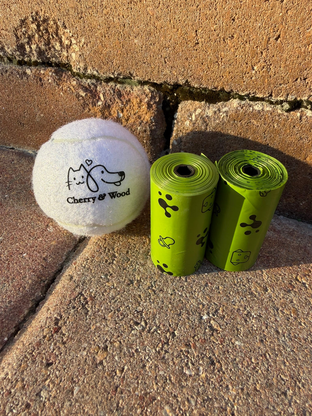 Dog poop bags shown with a tennis ball