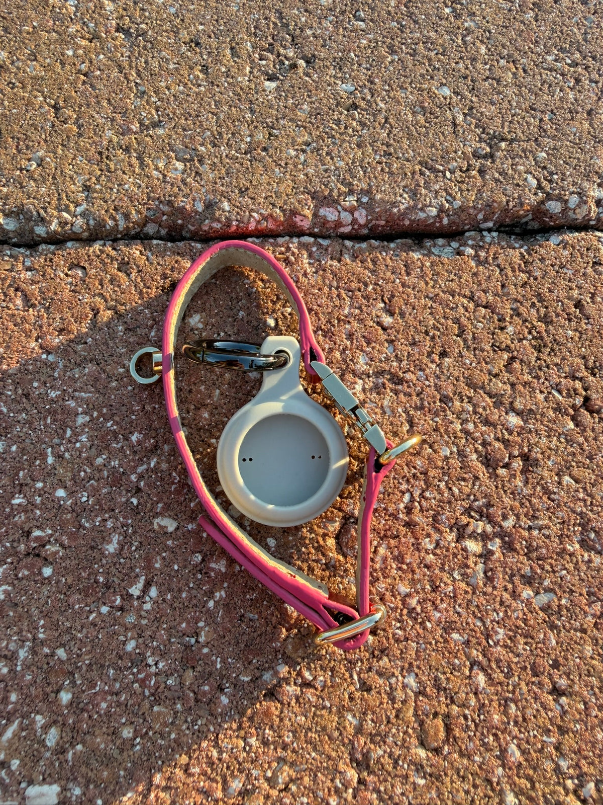 Red leather cat collar shown with the AirTag holder